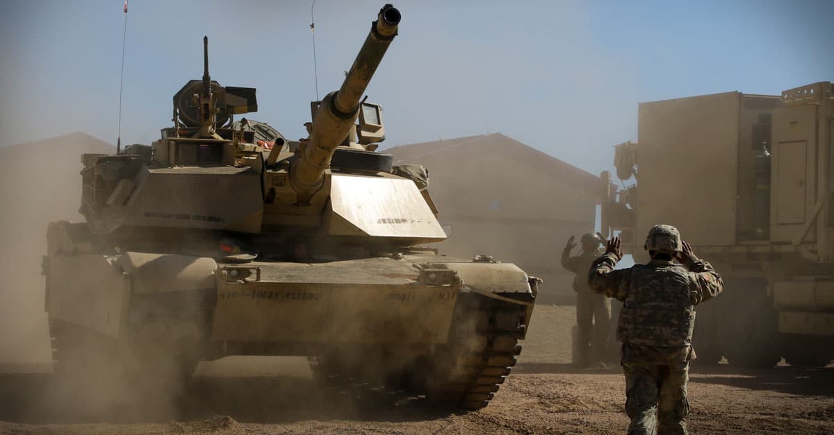 1 Abrams - soldier guides an M1A2 Tank commander to a maintenance area